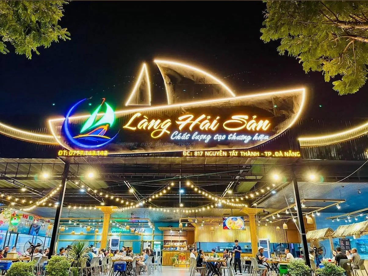 Biển hiệu Làng Hải Sản với hình con thuyền phát sáng