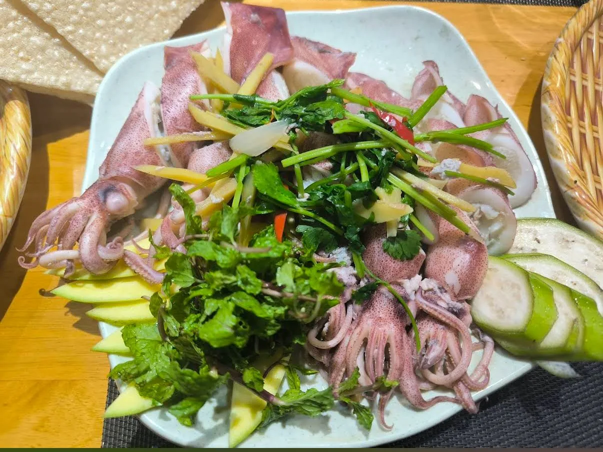 Món gỏi mực tươi trình bày cùng rau thơm và xoài xanh
